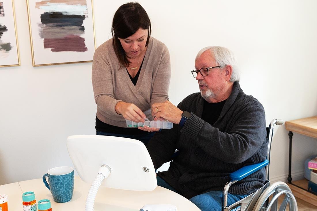 woman helping senior with medication